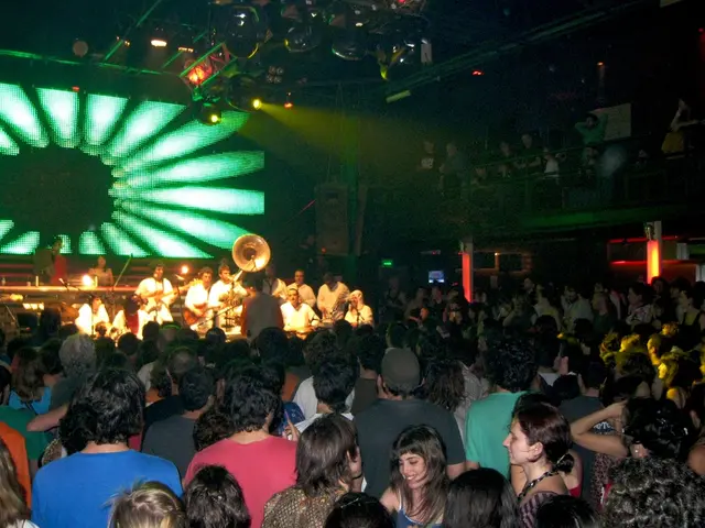 We can see group of people and we can see musical instruments. In the background we can see screen....