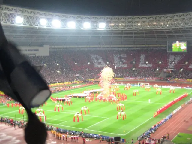 In this image we can see a stadium. In the stadium there are flood lights, iron grills, spectators,...