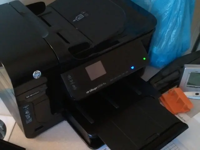 On a table we can see a digital timer, hp printer machine, blue polythene cover, Compact disc in a...