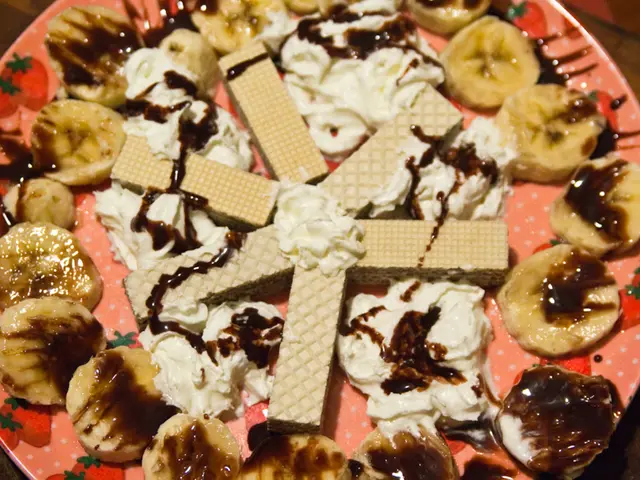 In this image we can see food items, banana slices and cream on a plate.